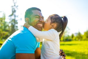 Daughter kissing her fathers cheek