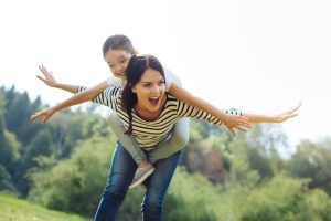 Mother giving daughter a piggy back ride