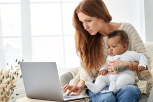 Single mother with laptop and baby
